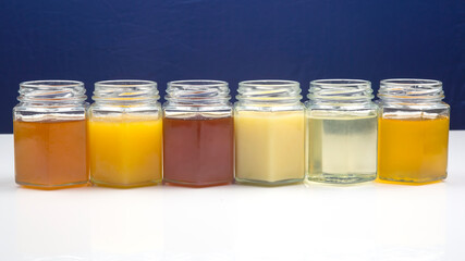 Hexagonal jars with different types and colors of fresh flower honey. vitamin food for health and life