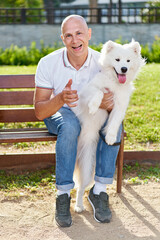 Samoyed dog with her man owner at the park playing together