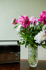 bouquet of flowers in vase. bouquet of white and pink peonies in a vase. Old radio on salt near flowers