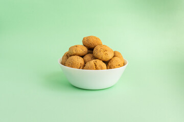 Oatmeal cookies on a white plate on a green background. Healthy food concept. High-quality photo