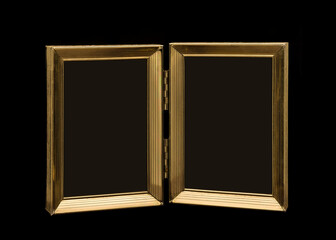 Old hinged double picture frame close-up isolated on black background
