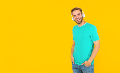 Fototapeta premium glad guy with bristle listen music on yellow background, lifestyle