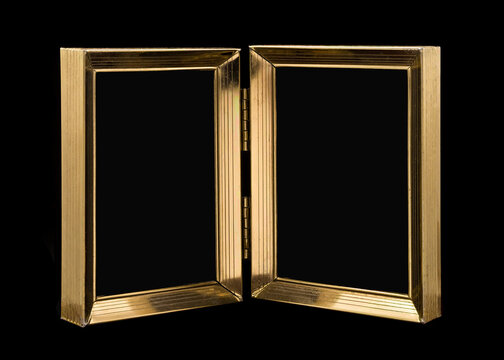 Old hinged double picture frame close-up isolated on black background
