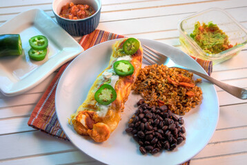 Top View of shrimp enchiladas on white natural wood surface