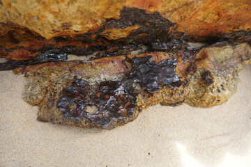 Selective focus raw cassiterite metallic ore of tin stuck on rock. Natural mineral from geological.