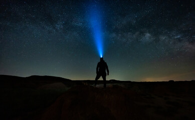 Fototapeta premium persona con linterna en la cabeza observando el cielo estrellado