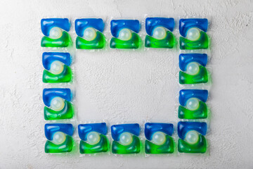 Capsules for washing laundry detergents for washing clothes in a washing machine on a white cement background.The concept of purity.Capsules with liquid laundry detergent for washing machine.