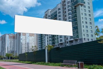 Big empty billboard with mock up place stands at urban sidewalk. Advertising and business promotion.