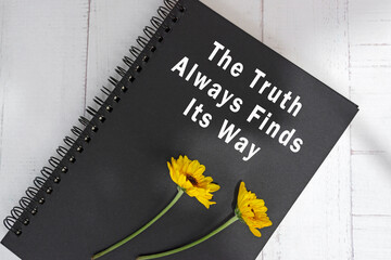 Motivational and inspirational quote on black notepad on wooden desk.