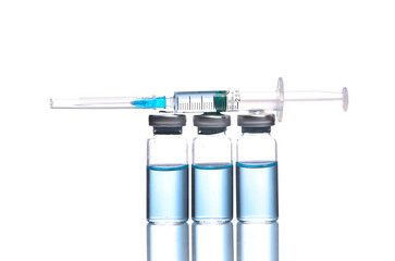 Vaccine bottles with blue liquid and syringe isolated on white background with reflection