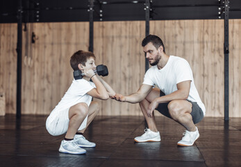 Teenager trains with personal trainer in the gym. Children's fitness