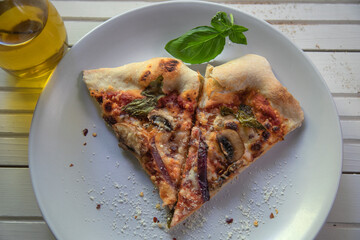 Top view of vegetarian pizza on white natural wood surface.