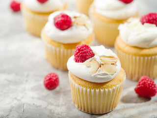 Muffins decorated with cream, raspberries, almonds. Isolated on white background. Lots of objects. Restaurant, hotel, patisserie, cafe, home cooking, culinary blog. Holiday invitation.