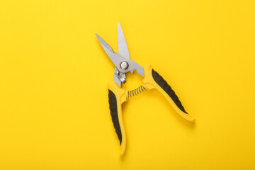 Garden pruner on a yellow background. Top view