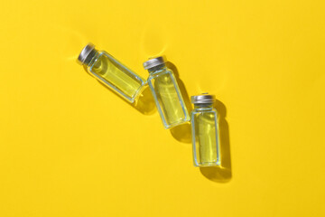 Vaccine bottle on yellow bright background. Top view