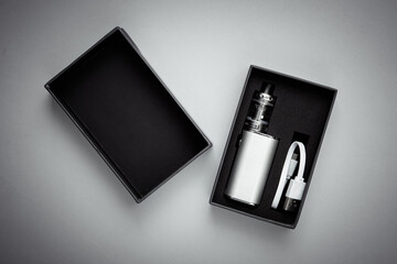 New vaping device in a box on a gray background