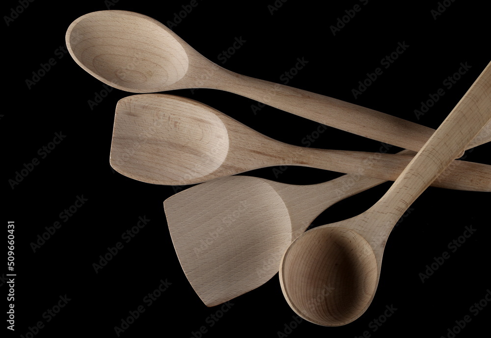 Wall mural Empty different wooden spoons, isolated on black, top view 