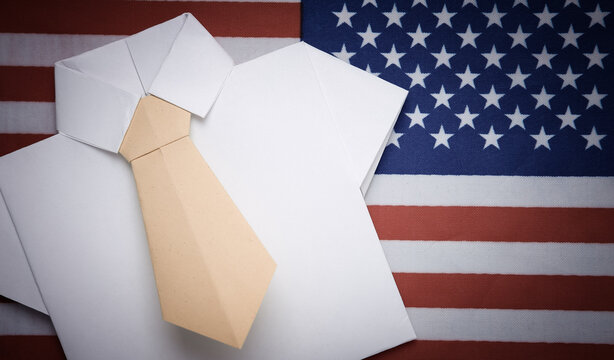 Origami shirt with tie on the background of the USA flag. Politics or business concept