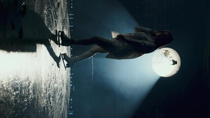 A woman skates on ice in an abandoned building. Silhouette of a female figure skater practicing spin and slide skills. Figure skating training. Skill development. Slow motion. Vertical video - Powered by Adobe