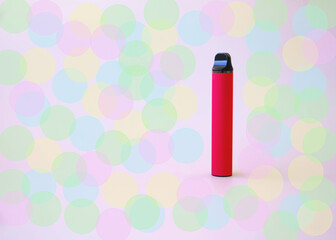 Fototapeta premium Red electronic cigarette vape on a multicolored background bokeh