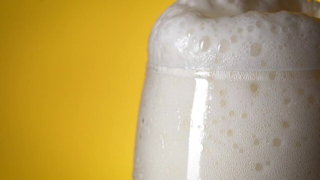Close up. Slowmotion. Beer is poured into a glass and a beautiful thick beer foam rises. Light beer. Cold delicious beer.