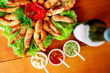 breaded shrimp with sauces and beer, plate decorated with salad