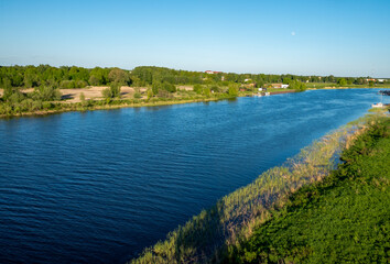 Fototapeta na wymiar River with green shores under blue sky