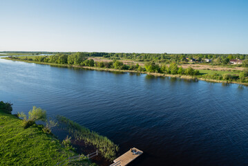 Obraz premium River with green shores under blue sky