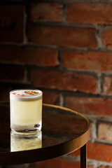 Pisco sour cocktail - whiskey with lime, egg white, sugar syrup in glass on dark background. Space for text