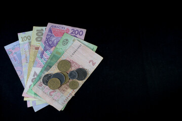 Ukrainian hryvnia of various denominations banknotes and coins on a black background