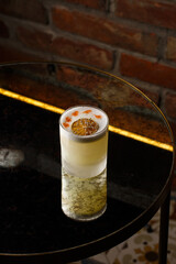 Pisco sour cocktail - whiskey with lime, egg white, sugar syrup in glass on dark background. Space for text