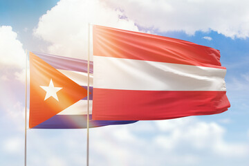 Sunny blue sky and flags of austria and cuba
