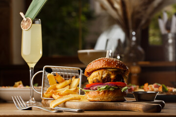Big cheeseburger with french fries isolated on white background. Hamburger with beef patty onion, tomato, lettuce pickles, melted cheddar, mustards, tomato jam, mayo