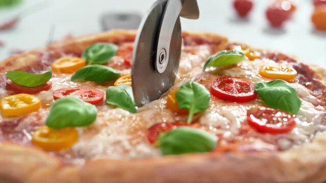 Vegetarian Pizza Margherita Cut into Slices with Roller Pizza Cutter in Slow Motion
