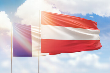 Sunny blue sky and flags of austria and france