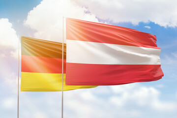 Sunny blue sky and flags of austria and germany