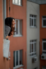 a girl looks out the window of a multi-storey building