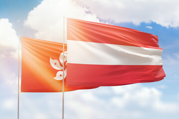 Sunny blue sky and flags of austria and hong kong