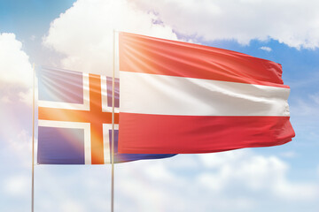 Sunny blue sky and flags of austria and iceland