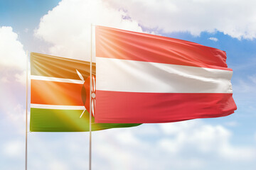 Sunny blue sky and flags of austria and kenya