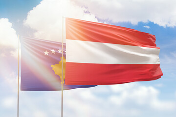 Sunny blue sky and flags of austria and kosovo