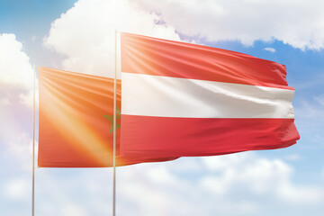 Sunny blue sky and flags of austria and morocco