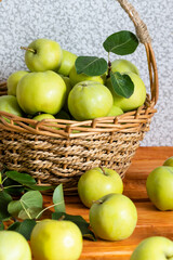Composition with juicy green apples in wicker basket on table. Copy space