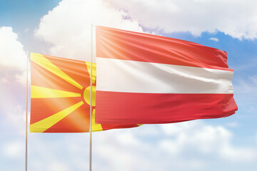 Sunny blue sky and flags of austria and north macedonia