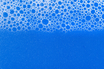 Soap foam. Background of dusty foam with bubbles of blue color for an inscription. Soap sud with copy-space