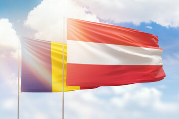 Sunny blue sky and flags of austria and romania