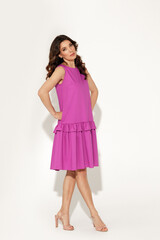 Full-length studio fashion portrait of elegant woman wearing purple dress against white wall. International women’s day, Mother’s day and spring concept.