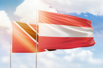 Sunny blue sky and flags of austria and trinidad and tobago