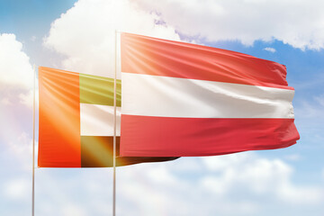Sunny blue sky and flags of austria and uae