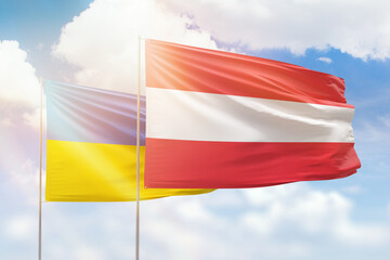 Sunny blue sky and flags of austria and ukraine